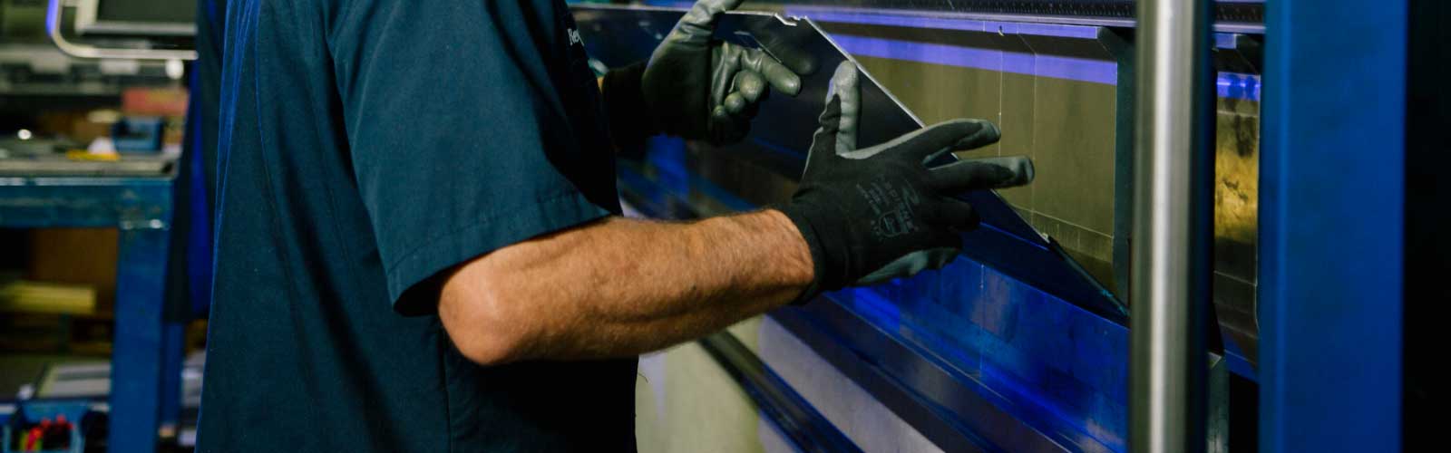 Wesgar's Terms and Conditions page banner image: person holding sheet metal part in bending machine