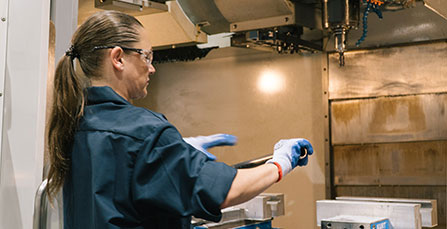 Wesgar employee holding a pipe in front of a sheet metal work station
