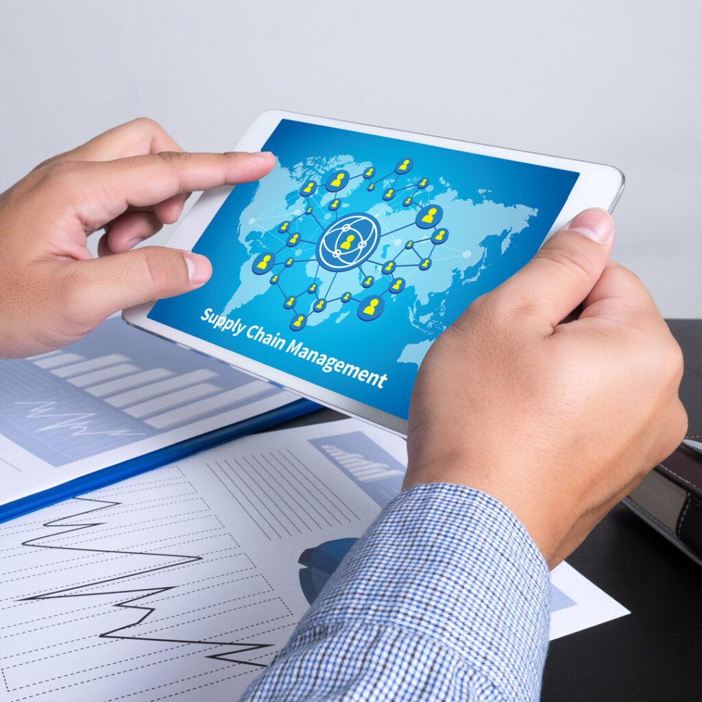 Wesgar blog cover image showing a person holding a tablet with a supply chain management graphic